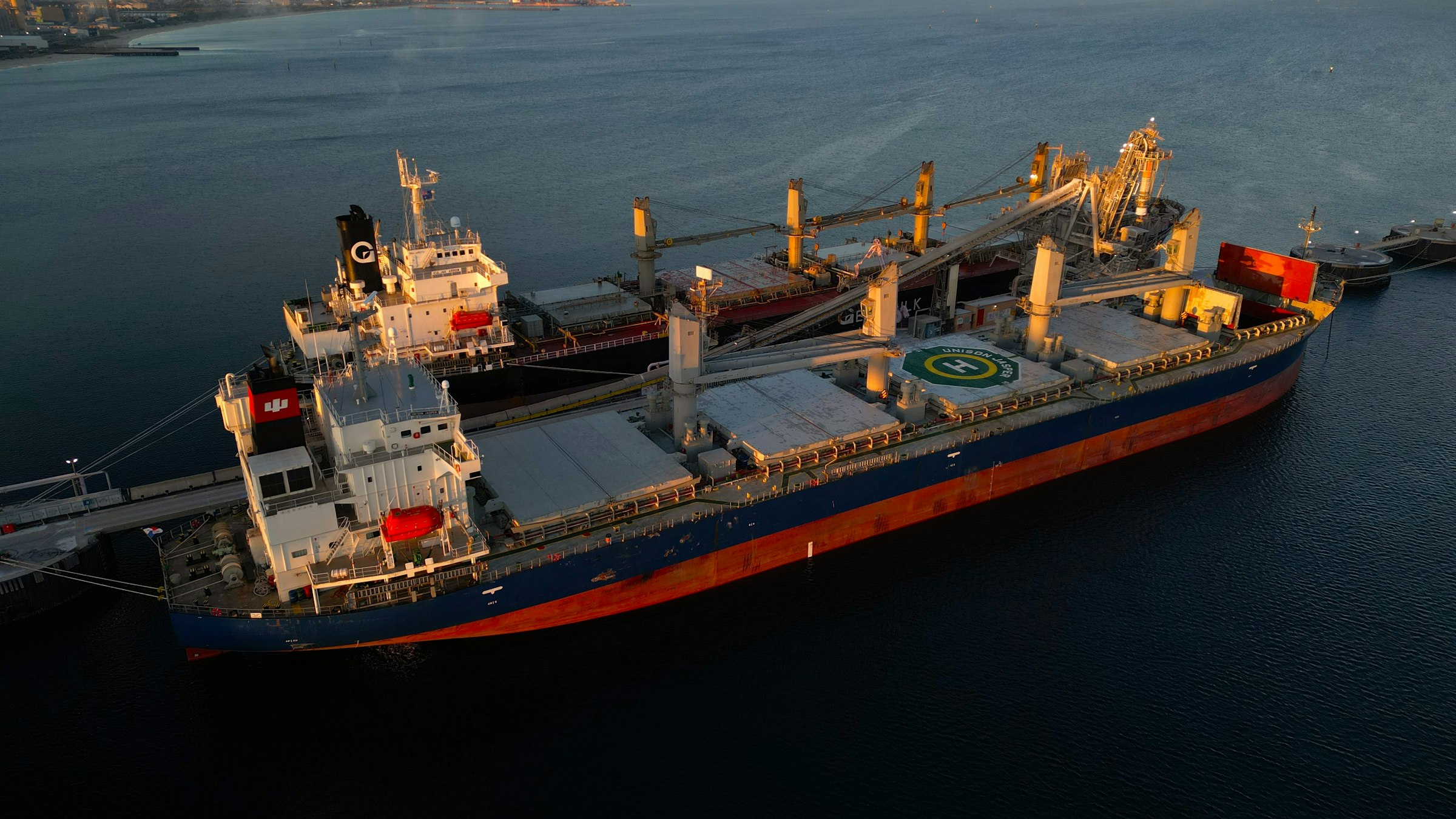 Aerial view of a geared bulk carrier moored at dusk